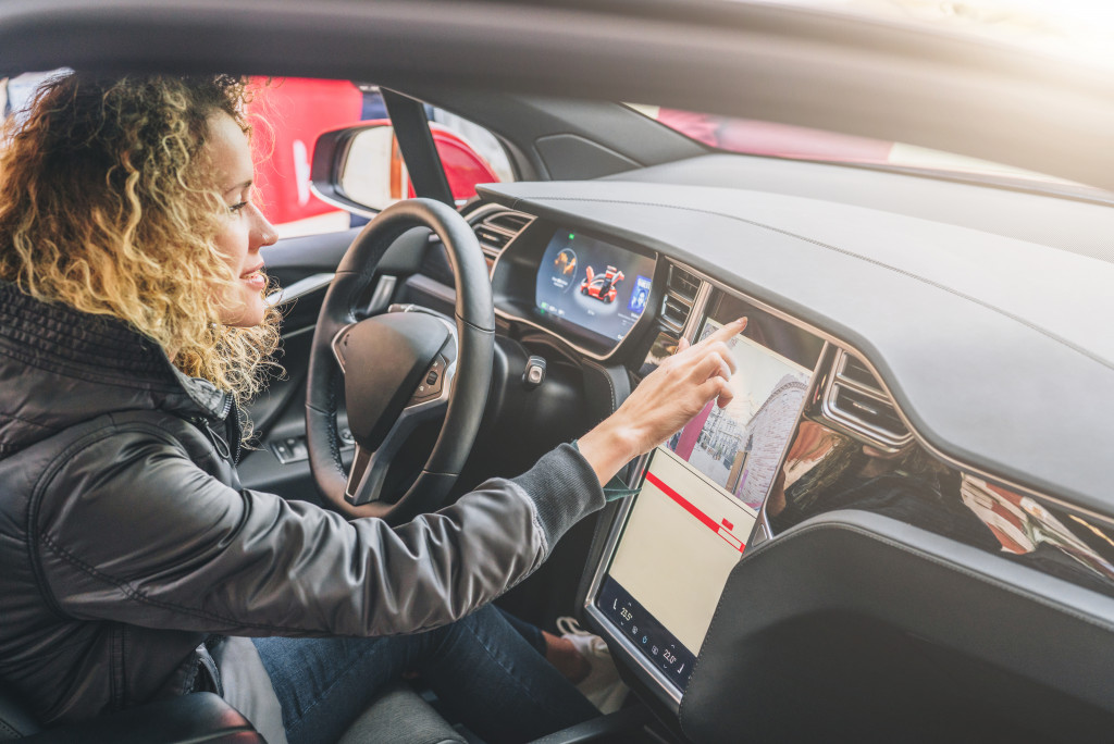young woman riding a car using her gadget