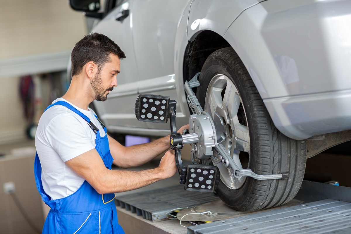 mechanic performing wheel alignment service